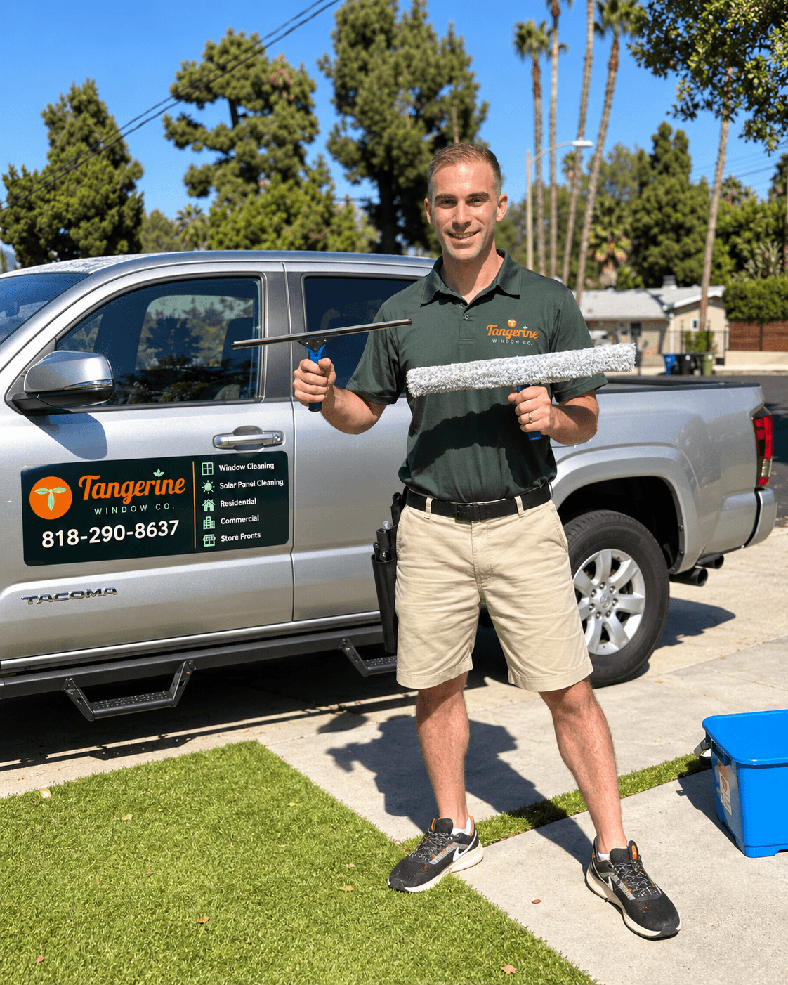 Ory, owner of Tangerine Window Co., holding a squeegee and a window washer beside the company truck